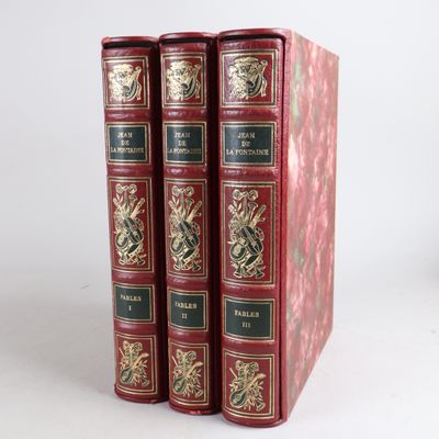 three red books sitting on top of each other on a white surface
