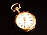 une montre de poche en or avec des chiffres romains