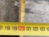 a measuring tape on a pole with a car in the background