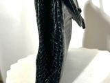 a black purse sitting on top of a white pedestal