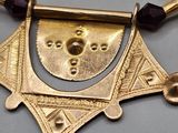 gold plated necklace with garnetts and beads on a gray surface