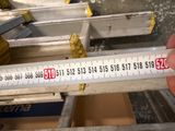 someone is measuring the height of a piece of metal with a ruler