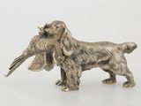 an antique silver dog figurine with a bird in it ' s mouth