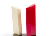 two pieces of red and white soap on a black stand
