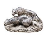 une statue représentant un lion et un hippopote, allongés sur un rocher