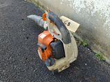 a chainsaw that is sitting on the ground next to a wall
