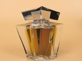 an image of a bottle of perfume sitting on top of a table