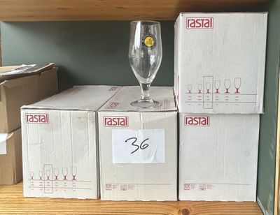 Plusieurs cartons de verres à vin sont empilés sur une étagère dans un magasin