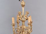 une image représentant un lustre en or surmonté d'un oiseau