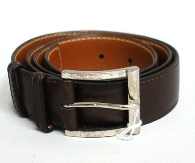 ceinture en cuir marron avec une boucle argentée sur un fond blanc
