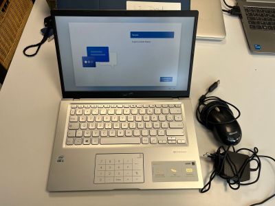 un ordinateur portable posé sur un bureau blanc