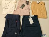 quatre paires de polos et de pantalons pour homme posées sur une table