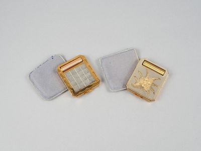 deux bijoux en or et en argent posés sur une surface blanche