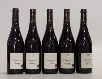 six bottles of red wine are lined up on a table