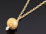un collier en or avec une perle et une chaîne
