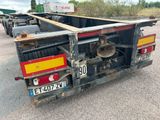 une photo d'un camion à plateau garé sur un parking