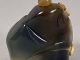 a picture of a black and green vase on a white surface