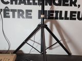 a television on a tripod in front of a wall