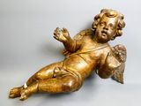 a gold statue of a baby laying on the ground