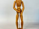 un mannequin en bois posé sur un socle