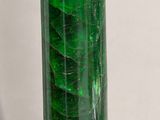 a green glass vase with a green leaf inside of it