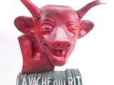 une sculpture rouge représentant une tête de taureau posée sur un livre