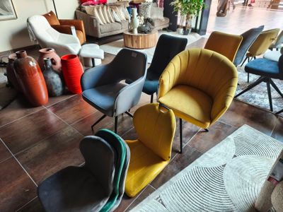 plusieurs chaises de différentes couleurs réunies dans un salon
