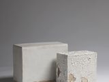 des parpaings sont empilés les uns sur les autres sur une surface blanche
