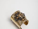 a close up of a gold ring with a flower design on it