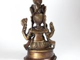 brass statue of a person holding a skull and a hand