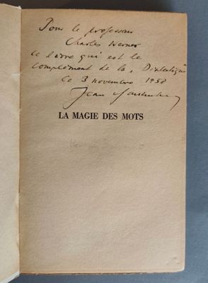 un livre ouvert avec une écriture dessus, posé sur une table