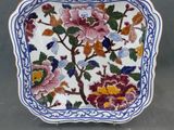une image représentant une assiette décorative ornée de fleurs et de feuilles