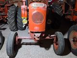 a red tractor that is sitting in a garage