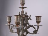 an antique brass candelab with four candles and a bird on it