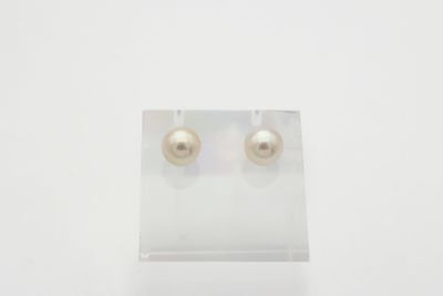une paire de boucles d'oreilles en perles posée sur un support en acrylique transparent