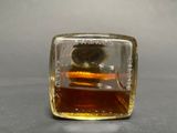 a glass block with a liquid inside of it on a table
