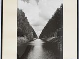 une photo en noir et blanc d'une rivière avec des arbres en arrière-plan
