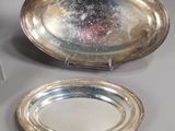 two silver plates and a spoon on a table