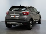 the rear end of a grey car parked in a room