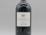 une bouteille de vin rouge posée sur une table blanche