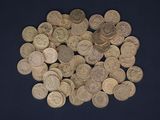 a pile of old coins on a blue surface