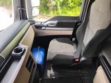 a seat in the back of a truck with a blue suitcase