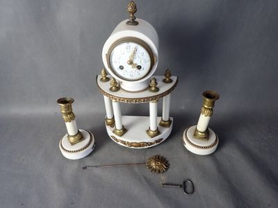 une horloge blanche et or posée sur une table