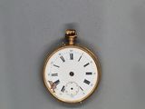 une montre de poche en or avec des chiffres romains sur le cadran