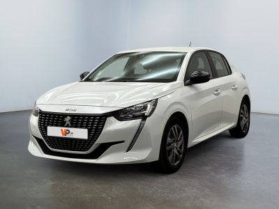 Une voiture blanche est garée dans une grande pièce au sol noir.