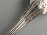 a silver spoon with a long handle on a table