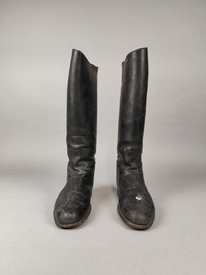 une paire de bottes en cuir noir sur fond blanc