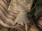 a close up of a doll with a dress and hat