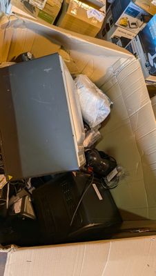 une boîte contenant un ordinateur portable, posée par terre