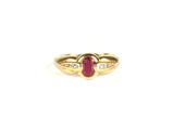 gros plan d'une bague en or avec un rubis et des diamants